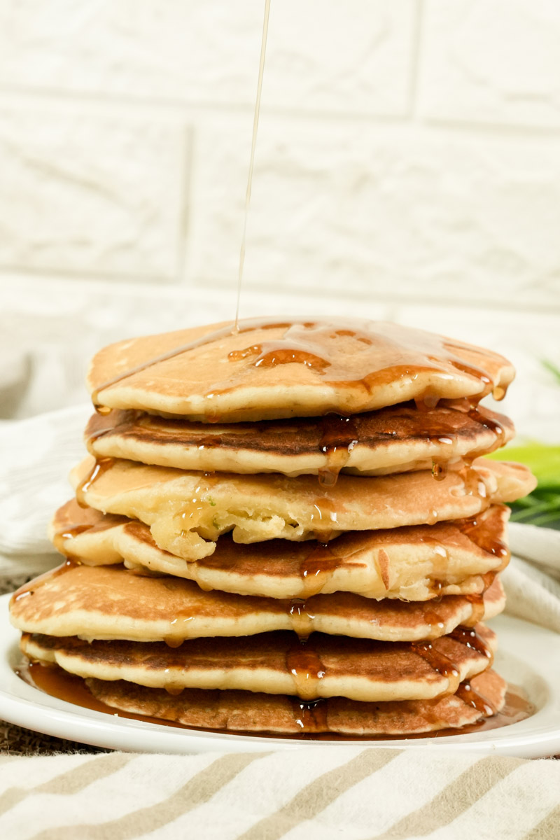 Side view of thick American pancakes stacked on a plate.