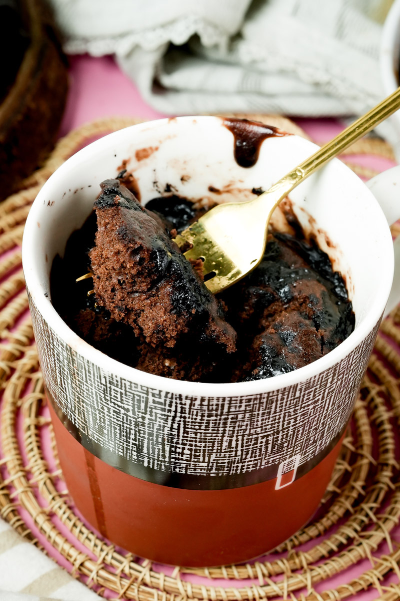 Taking a forkful of fluffy, warm chocolate mug cake from the cup