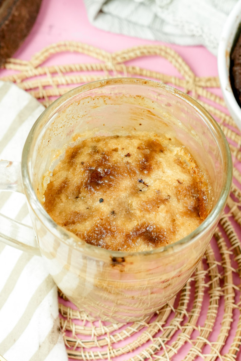 High-angle shot of a warm coffee mug cake featuring a caramelized sugar topping